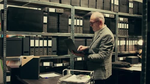 Man with Laptop Checks Archive Records