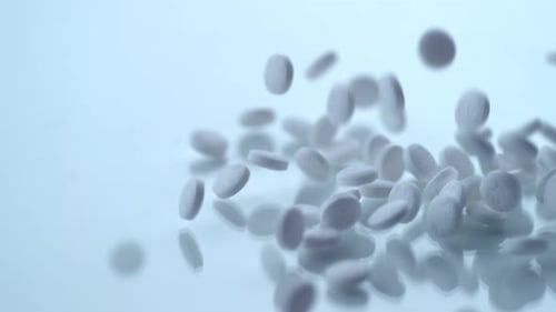 White Medicine Pills Falling on White Surface