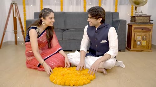 Young Couple Arranging Flowers on Floor Together