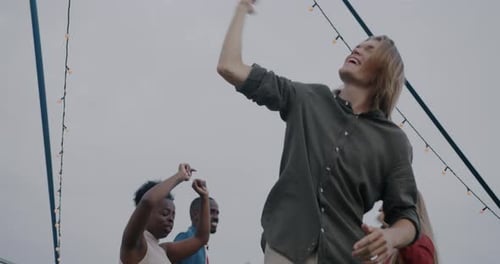 Cheerful Friends Dancing Together at Outdoor Party
