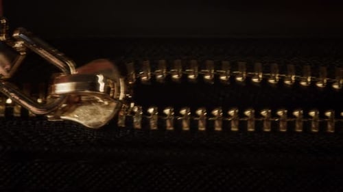 Person Opening Golden Zipper on Suitcase