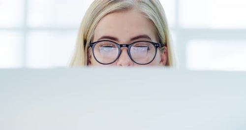Focused Woman Wearing Glasses Looking at Screen