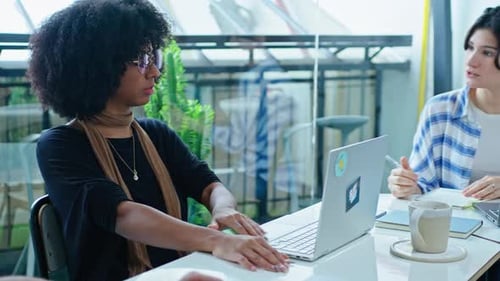 Two Women Working on Laptops in Modern Office