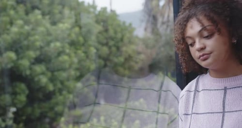 Woman with Curly Hair Looking Out Window