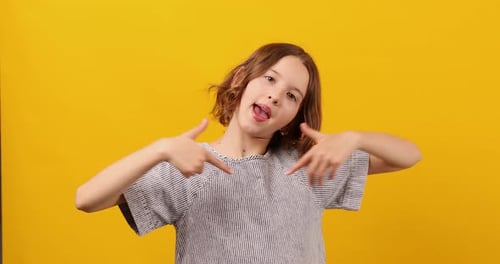 Happy Child Points Downwards on Yellow Background