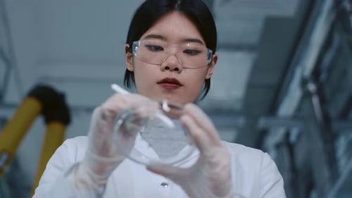 Young Adult Woman Examining Plant Samples in Lab