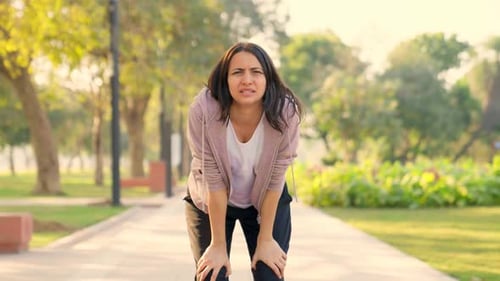 Woman Jogging Stops to Catch Her Breath in Park