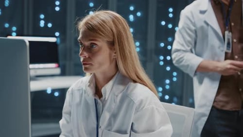 Data Center Blonde Attractive Female Support IT Specialist Working on Computer Two Professional