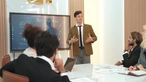 Confident Man Presents Business Plan to Colleagues