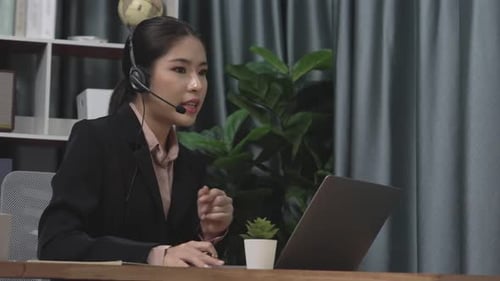 Woman in Home Office Talks on Laptop Headset