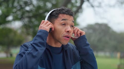 Fitness, park and man with headphones for music, streaming playlist and radio for workout