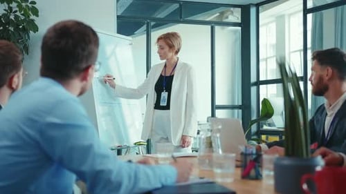 Businesswoman Presents Data to Colleagues in Modern Office