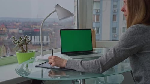 Woman Working on Graphic Tablet at Desk