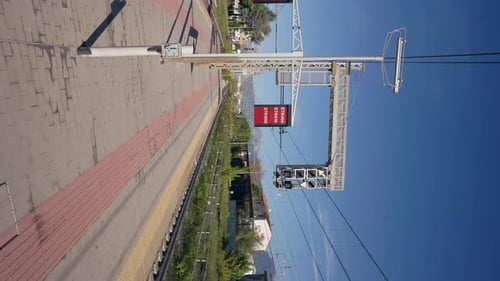 Vertikales Video eines Bahnhofs ohne Menschen im Sonnenschein, Weitwinkelaufnahme, leerer Transportplattform
