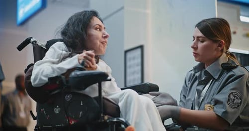 Security Checkpoint Female TSA Officer Checking Woman with Disability in Airport Terminal