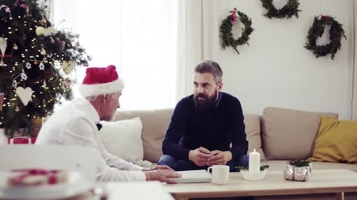 Father and Son Talking at Christmas Indoors