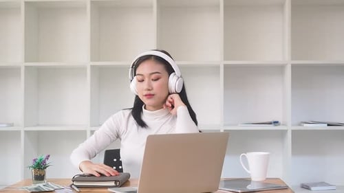 Woman Listening to Music at Desk at Home