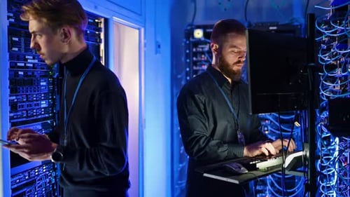 Technicians Working in a Blue Lit Server Room