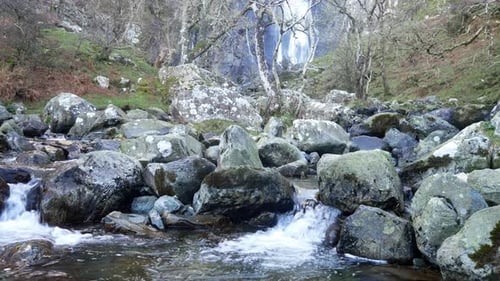 Rocky mountain cascading waterfalls flowing into jagged river rocks and boulders wilderness