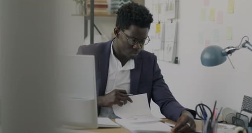 Serious Office Worker Writing Business Document Working Alone in Office Room
