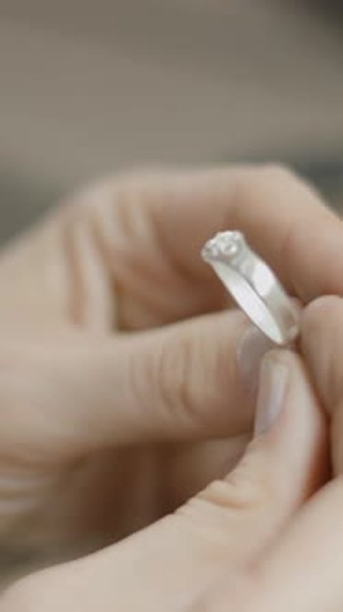 Close Up of Fingers Holding Silver Ring