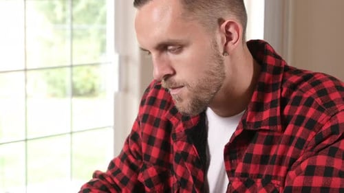 Focused Young Man Working on Laptop at Home