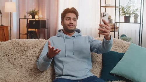 Man Video Chats on Smartphone at Home