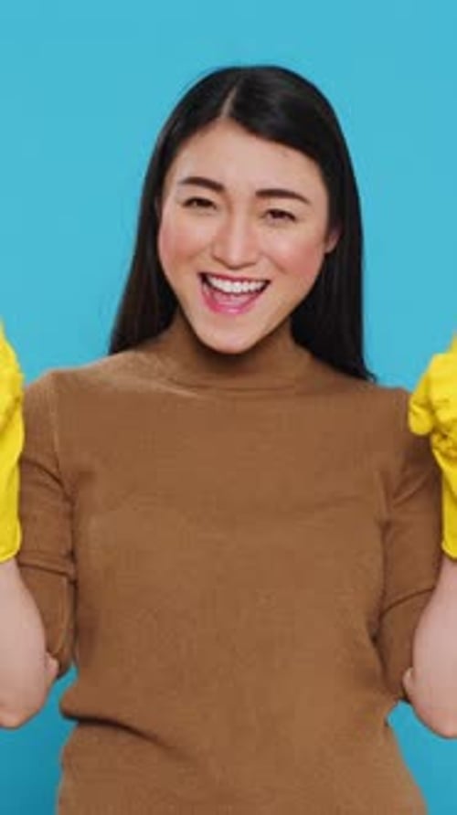 Woman Smiling with Yellow Cleaning Gloves on Blue