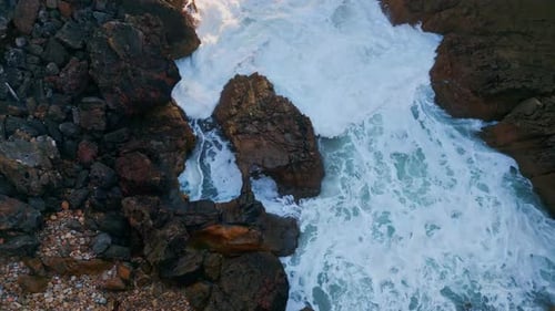 Dangerous Rocky Sea Shore with Stormy Foaming Water Crashing Stones Aerial View