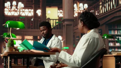 Two Medical School Scholars Focusing on Their Studies in a Traditional Library