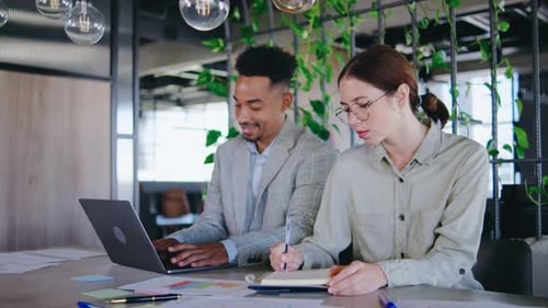 Man and Woman Discussing Project at Workplace