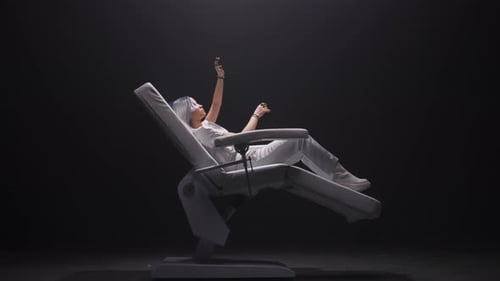 Young Woman in Futuristic Chair Wearing VR Headset