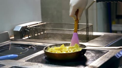 Pasta with sauce stirred in a restaurant kitchen