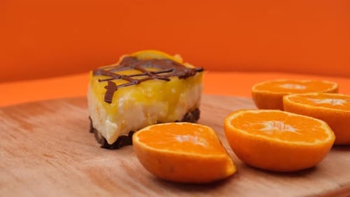 Orange Cake Slice with Chocolate on Wooden Plate