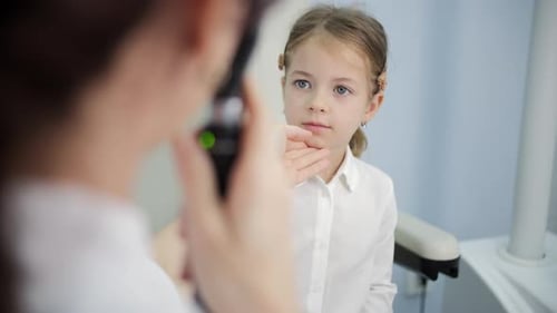 Doctor Performing Eye Examination for Young Girl