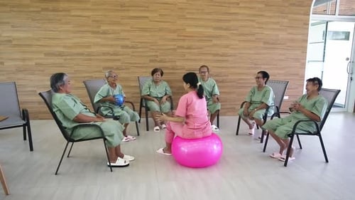 Seniors Exercising with Ball During Physical Therapy Session