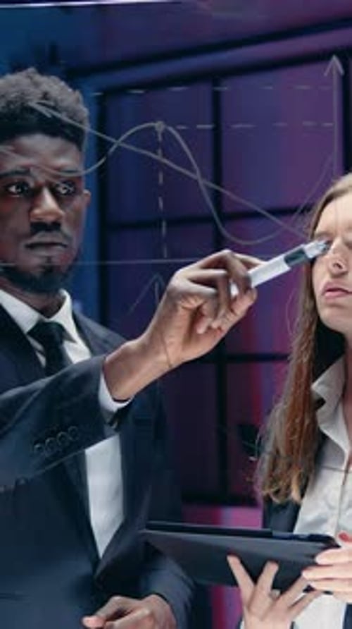 Business Team Discussing Data on Transparent Whiteboard