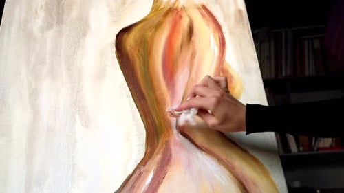 Beautiful woman painting with watercolors at an art gallery workshop