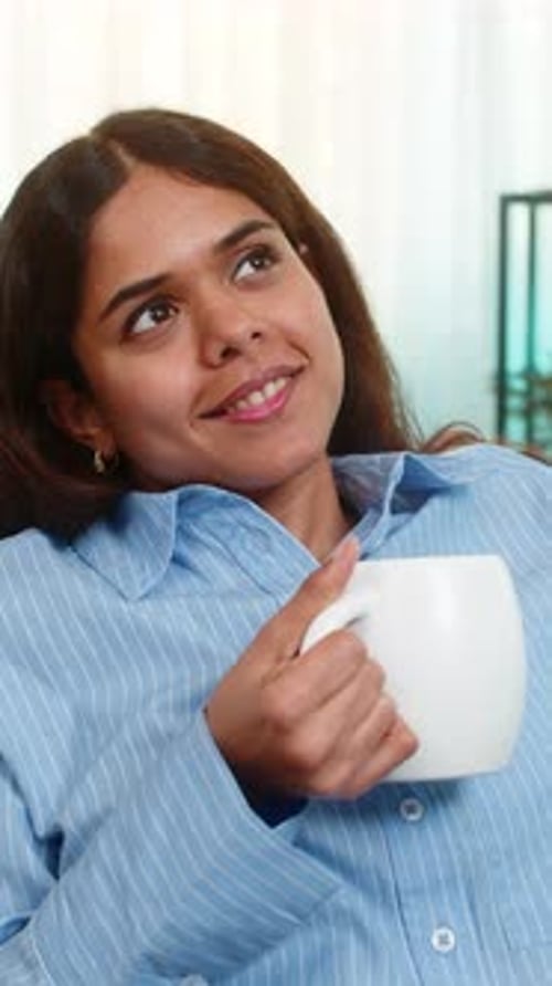 Woman Enjoying Coffee and Smiling While Relaxing