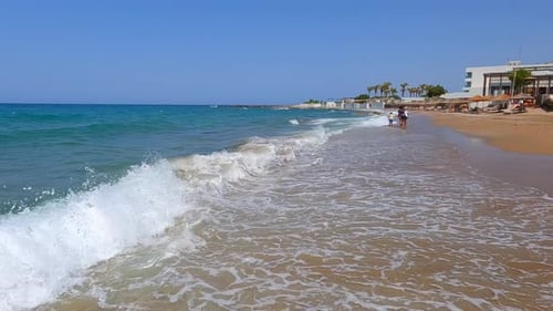 the turquoise sea spills onto the beach of Crete