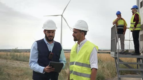 Professional Team of Engineer and Electrical Technicians Working in Wind Turbine Electricity Farm