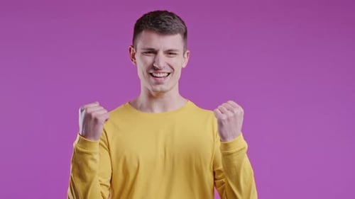 Man Celebrating Victory on a Purple Background