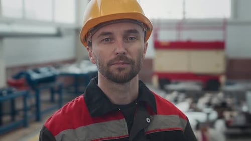 Portrait of Industrial Factory Worker in Hard Hat at Workplace