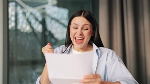 Excited Woman Reads Document With Successful Expression