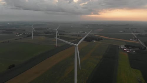 Luftbild von Windturbinen, die bei einem schönen Sonnenaufgang nach einer frühen Morgendämmerung Strom erzeugen