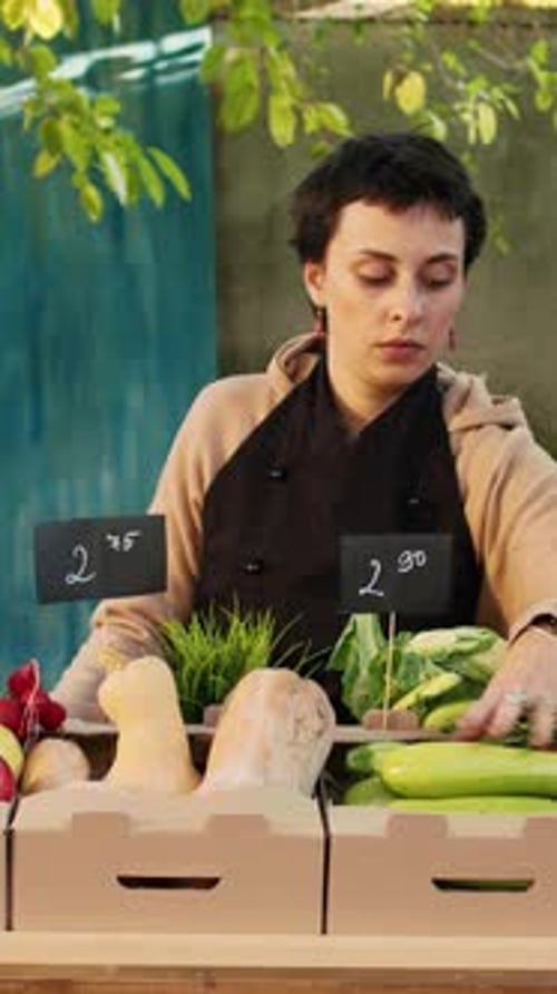 Woman Arranges Vegetables at Farmer's Market