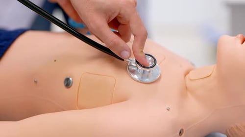 Examining Medical Dummy with Stethoscope in Training Facility