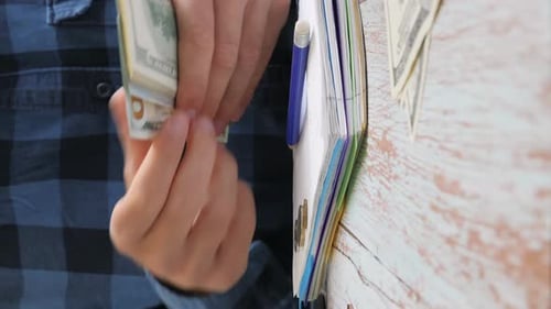 Calculating money, accounting bills, putting money in glass jar. Vertical video