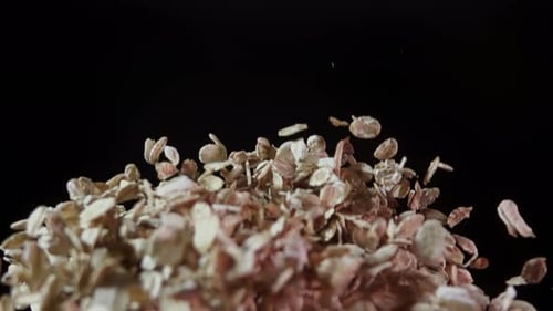 Oatmeal in the Air Close Up Oats Flying Up in Slow Motion on a Black Background