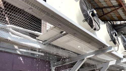 Closeup Lowangle View of Air Conditioning System Installed on Wall of Building with Rotating